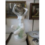 A Herand porcelain model, of a seated naked female doing her hair, height 22ins -- Good condition,