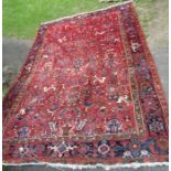An Eastern design red ground rug, with heavily patterned field, 90ins x 133ins