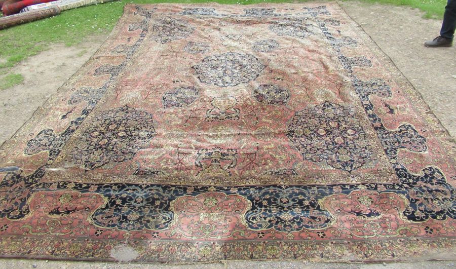 A large rug, decorated with urns, animals and flowers, with similar border, 135ins x 180ins