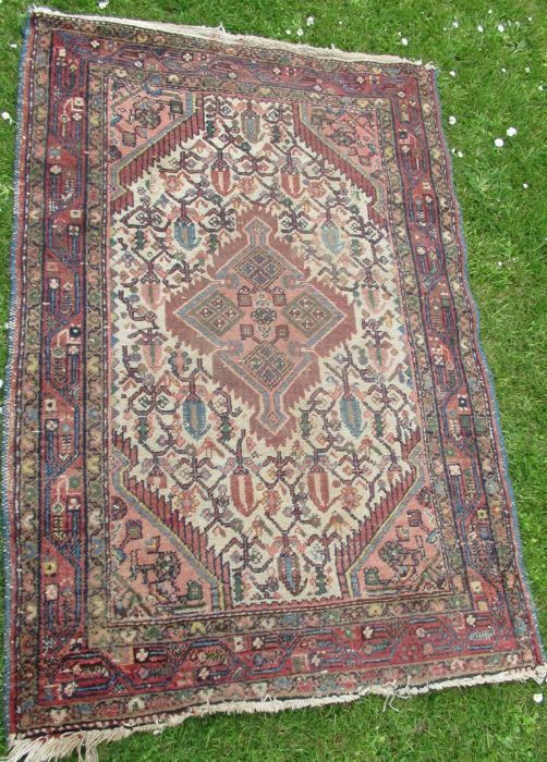 An Eastern design rug, with diamond to the white ground field, 40ins x 60ins