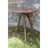 An Antique oak cricket/gypsy table, raised on three bobbin turned legs, diameter 17.5ins, height
