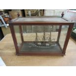 A painted wooden model, of a three masted sailing ship, in a glazed mahogany case, 12ins x 18ins x