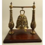 An Antique brass ceremonial or tomb bell, with pierced bands of decoration and script, on a cross