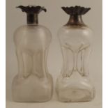 Two glass glug glug decanters, one with ribbed body, both with hallmarked silver tops, one by