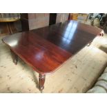 A 19th century mahogany extending dining table, raised on reeded legs, with four leaves, length