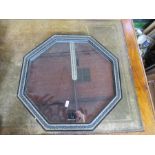 An octagonal wall mirror, the black and gilt frame decorated with flowers, overall diameter 18ins