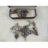 A silver charm bracelet together with cuff links including gold examples