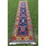 An Eastern design blue and red ground runner, 127ins x 28ins