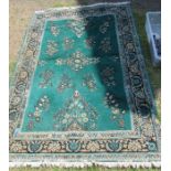 A green ground Eastern style rug, 61ins x 88ins