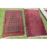 Two Eastern prayer rugs, decorated in red and blue, 52ins x 33ins and 60ins x 35ins