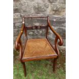A Regency design open arm chair with rope twist back and a cane seat