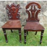 Two 19th century mahogany hall chairs, with carved backs and solid seats, raised on turned front