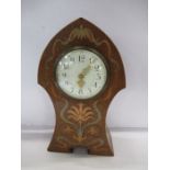 An Art Nouveau mantel clock, of typical form inlaid with pewter and cooper and a stylized floral