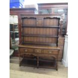 A reproduction three drawer dresser, with close boarded delft rack over, width 54ins, depth 17.5ins,