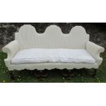 A Queen Anne style three seater settee, with shaped back, raised on carved mahogany legs and