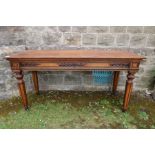 A 19th century oak serving table with carved decoration raised on reeded legs