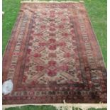 An Eastern design rug, decorated with a repeating field of motifs, on a brown beige, 86ins x 59ins