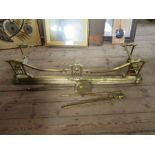 A late 19th century Art Nouveau brass fender, width 52ins, together with fire irons
