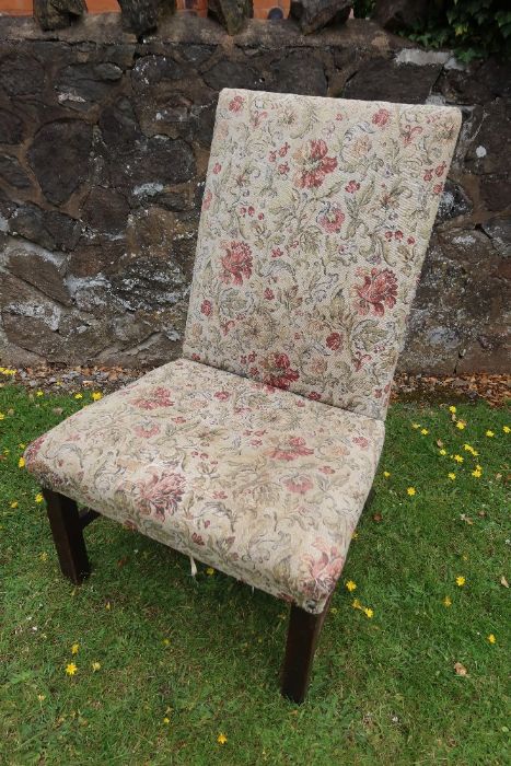 A 19th century upholstered easy chair raised on square legs united by stretchers