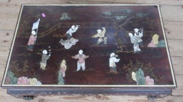 An Eastern design low coffee table, inlaid with figures in landscape, 20ins x 32ins, height 14ins