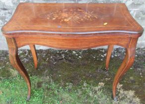 A 19th century quarter veneered fold over mahogany games table, with inlaid floral decoration,