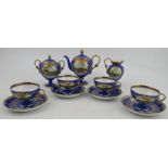 A Noritake coffee set, decorated with landscapes to a blue ground, comprising four cups and saucers,