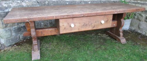 An antique oak serving table, with a plank top raised on shaped legs united by a stretcher fitted