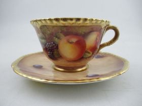 A Royal Worcester cabinet cup and saucer, decorated with hand painted fruit, signed N.Creed