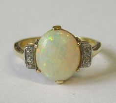 An 18ct opal and diamond ring, the central oval cabochon, with four old cut diamonds to the