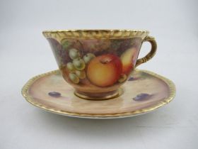 A Royal Worcester cabinet cup and saucer, decorated with hand painted fruit, signed N.Creed