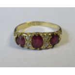 An 18ct three stone ruby ring, set with diamonds between the rubies, weight 2.9g