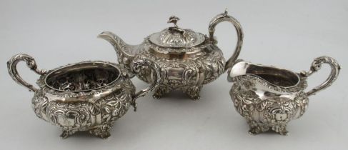 A late Georgian Irish silver three pieces tea set, heavily embossed with panels of flowers and