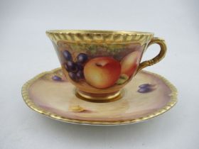 A Royal Worcester cabinet cup and saucer, decorated with hand painted fruit, signed N.Creed