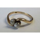 A two stone cross-over diamond ring, total diamond weight estimated 0.25ct. weight 2.2g , small chip