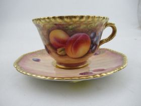 A Royal Worcester cabinet cup and saucer, decorated with hand painted fruit, the cup, signed N.