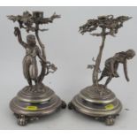 A pair of silver plated candlesticks, formed as girls standing under trees, to circular bases, on