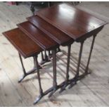 A nest of four mahogany tables, of rectangular form raised on ring turned legs, 22ins x 15ins,