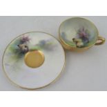 A Royal Worcester miniature tea cup and saucer, the saucer and the interior of the cup decorated