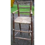 A child's high chair or correction chair, with bobbin turning and wicker seat