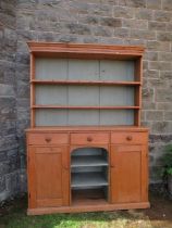 A pine dresser, with boarded plate rack over base width 59ins, height 81ins, depth 17ins