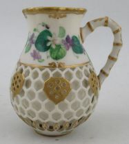 A Kerr & Binns Worcester reticulated jug, decorated with painted flowers and a bird, height 4ins