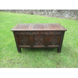 An antique oak coffer with carved decoration to the front 47.5ins x 22ins, height 26ins