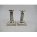 A pair of silver dwarf candlesticks, with bead edge and fluted column, London 1902, height 5ins