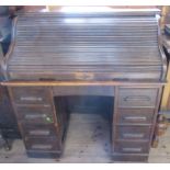 An oak roll top desk, with serpentine tambour opening to reveal drawers and pigeon holes, with