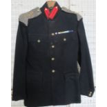 A Jones, Chalk & Dawson dark blue military tunic, with mesh epilates, military badges and medal
