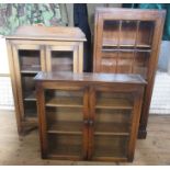 Two oak glazed floor standing cabinets, together with an oak glazed wall cabinet