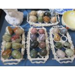 A collection of marble eggs, together with metal stands