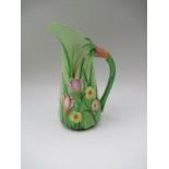 A Carlton Ware green ground jug, decorated with relief irises and flowers, height 8.5ins