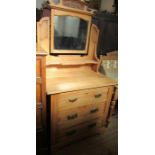 An Edwardian pine dressing chest, with carved decoration over the mirror, the base fitted with three