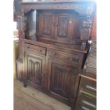 A 20th century carved oak court cupboard, fitted with a cupboard to the upper section and two